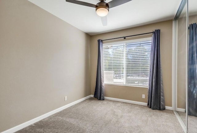 carpeted spare room with ceiling fan