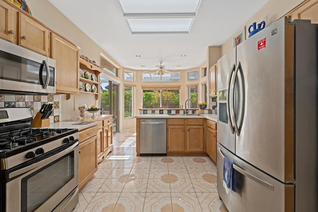 kitchen with sink, decorative backsplash, light tile patterned floors, kitchen peninsula, and stainless steel appliances