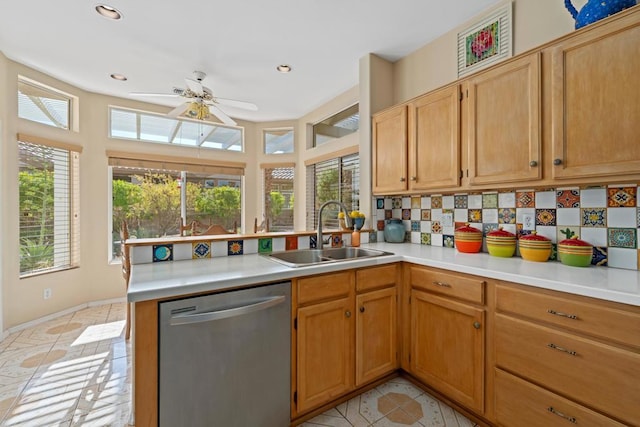 kitchen with tasteful backsplash, sink, stainless steel dishwasher, ceiling fan, and kitchen peninsula