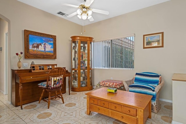 living area featuring light tile patterned floors and ceiling fan