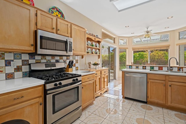 kitchen with sink, light tile patterned floors, ceiling fan, stainless steel appliances, and tasteful backsplash