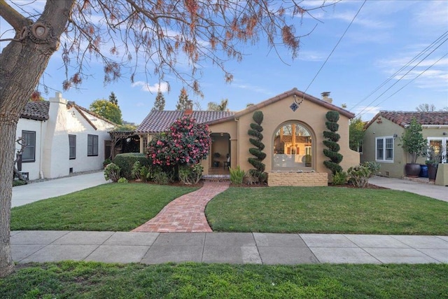 mediterranean / spanish house featuring a front lawn