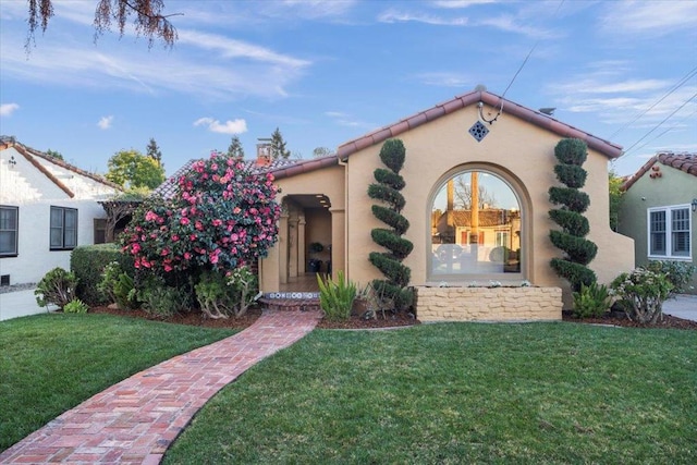 mediterranean / spanish home with a front lawn