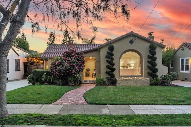 mediterranean / spanish house featuring a lawn