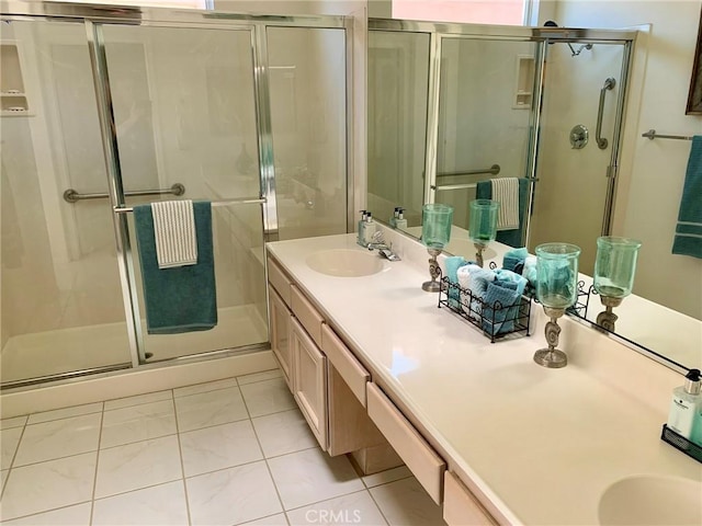 bathroom featuring vanity, a shower with shower door, and tile patterned flooring