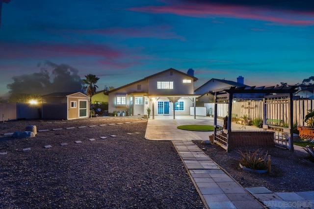 view of front of house with a shed, a pergola, and a patio