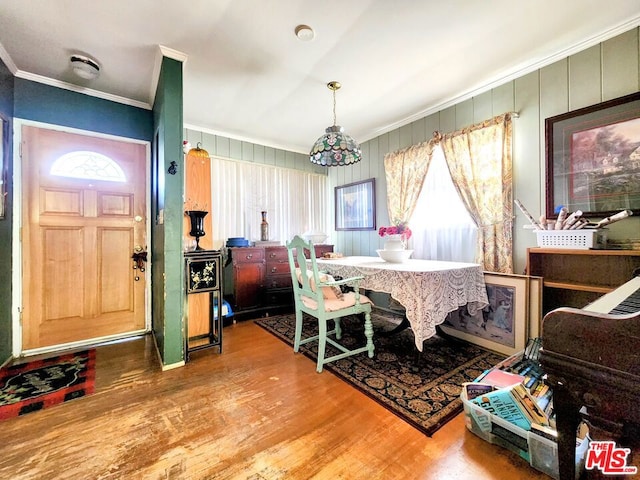 dining space featuring crown molding, wood-type flooring, and a healthy amount of sunlight