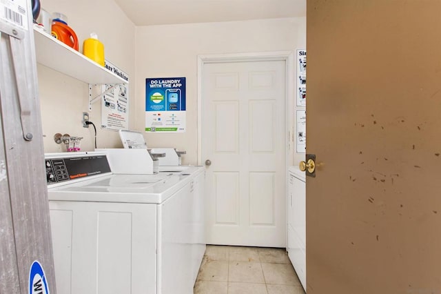 laundry area featuring washer and clothes dryer and light tile patterned floors