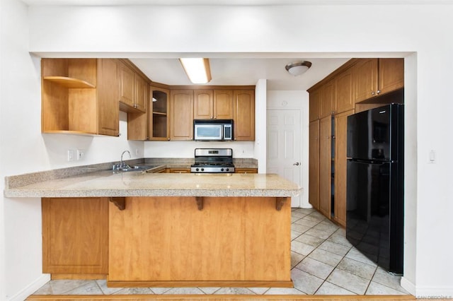 kitchen featuring light tile patterned flooring, stainless steel appliances, kitchen peninsula, and sink