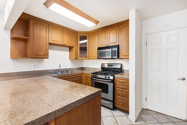 kitchen with sink, stainless steel appliances, kitchen peninsula, and light tile patterned flooring