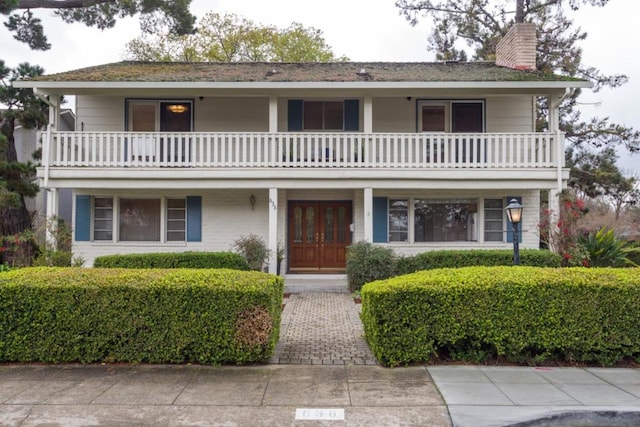 view of front of house with a balcony and french doors