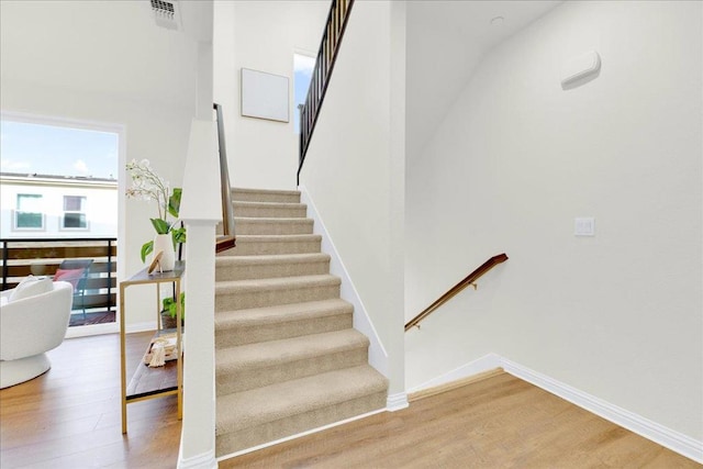 staircase with hardwood / wood-style floors