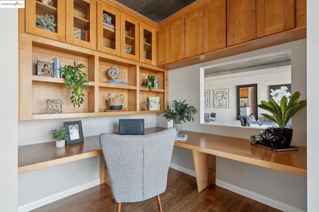 office with dark wood-type flooring and built in desk