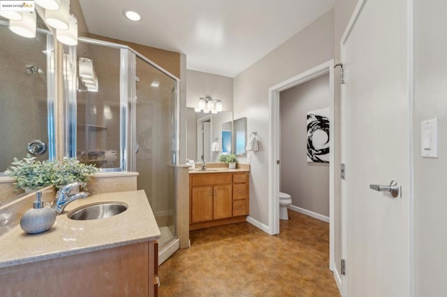 bathroom with vanity, toilet, and a shower with shower door