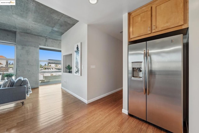 kitchen with light hardwood / wood-style floors and stainless steel fridge with ice dispenser