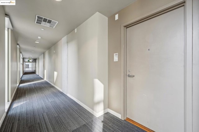 corridor featuring dark colored carpet