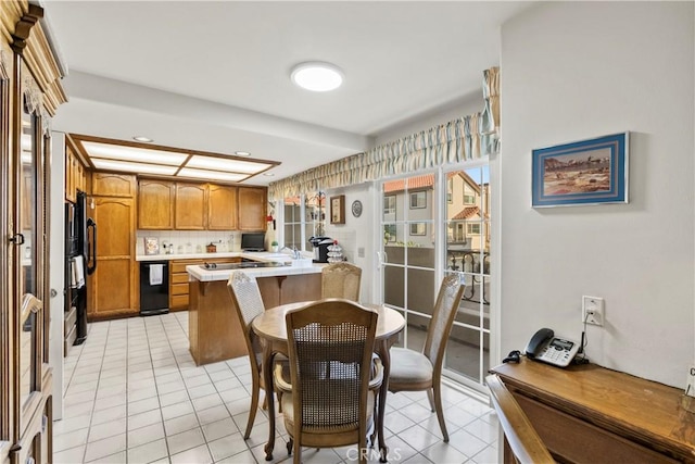 kitchen with a kitchen bar, tasteful backsplash, light tile patterned floors, black dishwasher, and kitchen peninsula