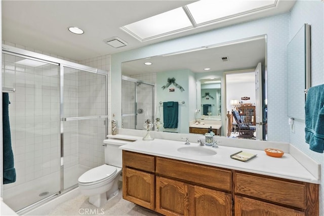 bathroom with vanity, toilet, and a shower with shower door