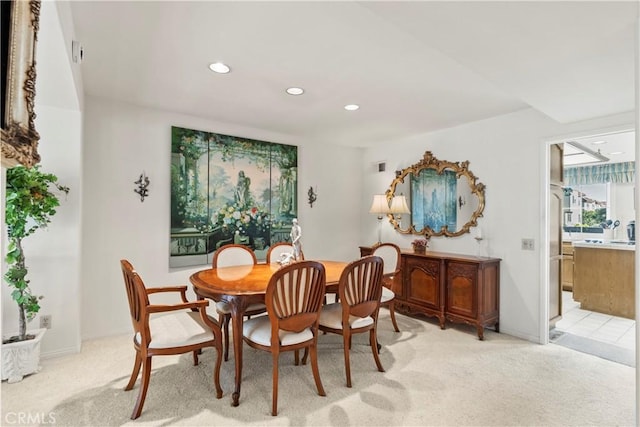 dining space featuring light carpet