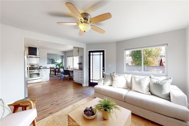 living room featuring hardwood / wood-style flooring, ceiling fan, and a wealth of natural light