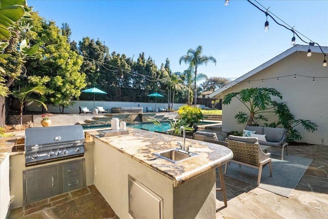 view of patio with sink, a fenced in pool, a grill, area for grilling, and pool water feature