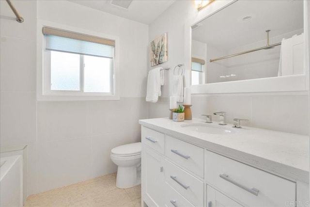 bathroom with a shower, tile walls, tile patterned flooring, vanity, and toilet