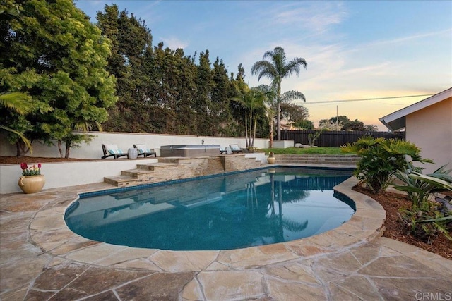 pool at dusk featuring a patio