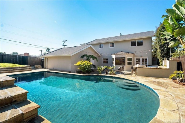 view of swimming pool featuring area for grilling, an outdoor bar, and a patio