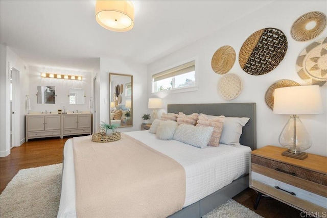 bedroom featuring dark wood-type flooring and ensuite bath