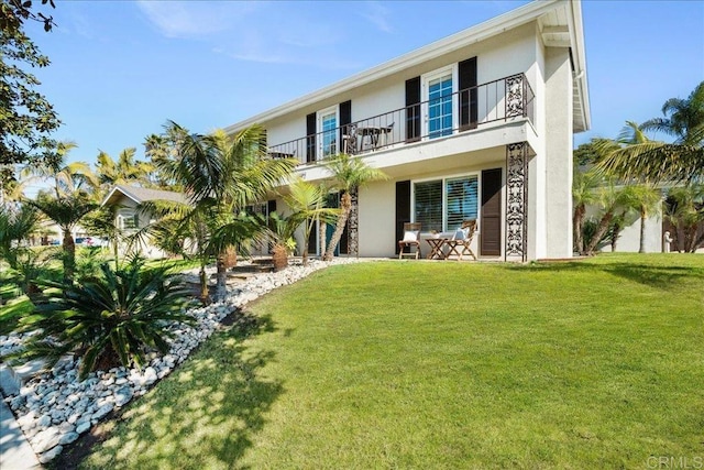 view of front of property with a balcony and a front yard