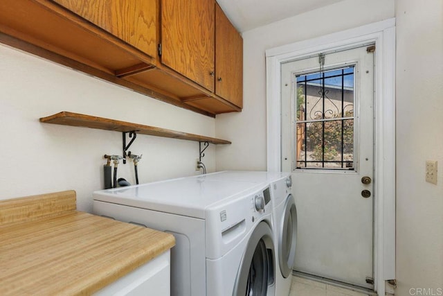 washroom featuring cabinets and washer and clothes dryer