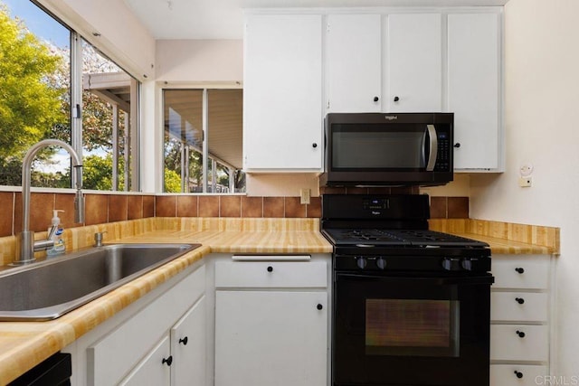 kitchen featuring white cabinetry, sink, and gas stove