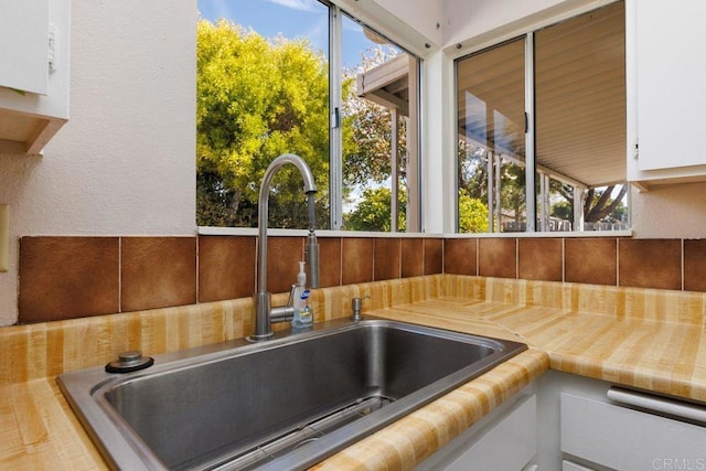 room details featuring white cabinetry, sink, and a hot tub