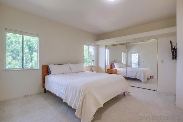 carpeted bedroom with multiple windows and a closet