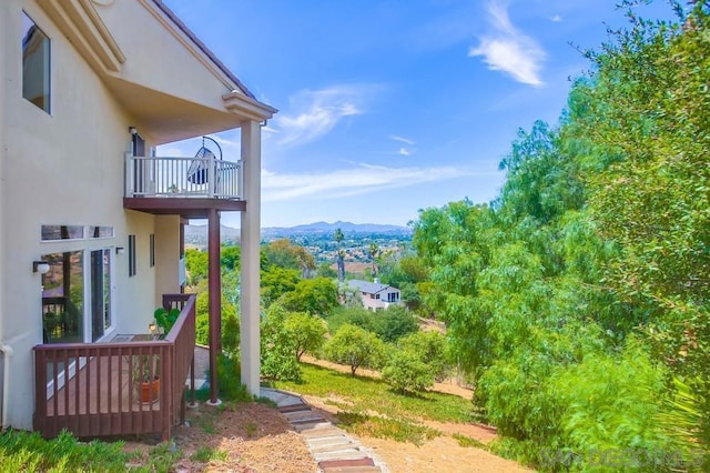 view of yard with a balcony and a mountain view