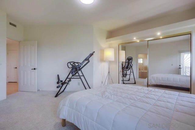 bedroom featuring light carpet and ensuite bath