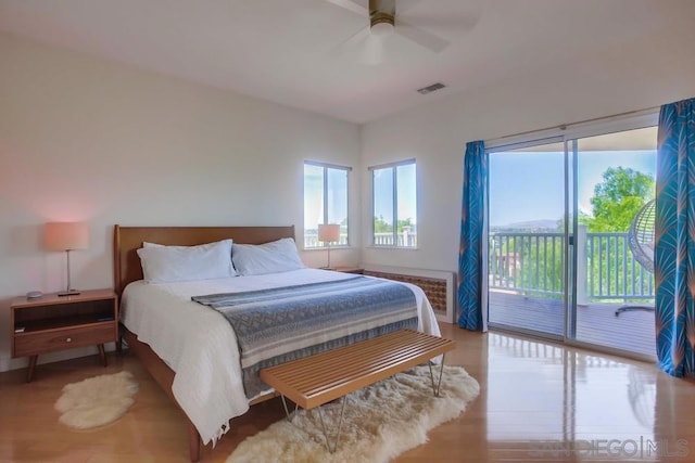 bedroom with wood-type flooring, access to outside, and ceiling fan