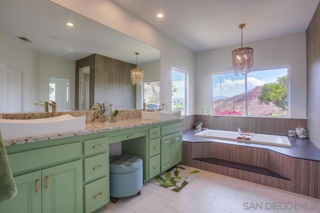 bathroom with vanity, a bathing tub, tile patterned flooring, and a notable chandelier