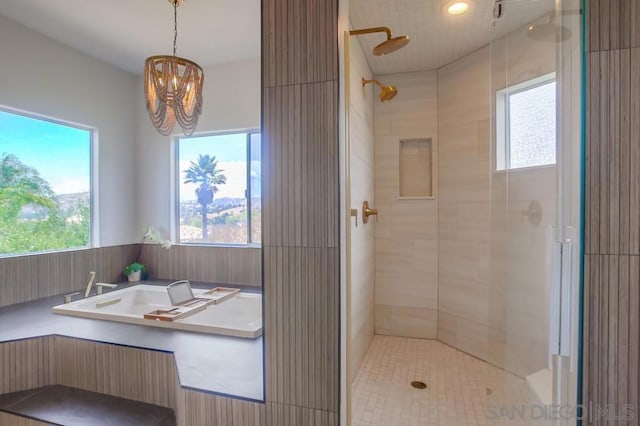 bathroom featuring a notable chandelier and shower with separate bathtub