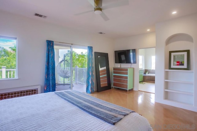 bedroom featuring ensuite bath, access to outside, ceiling fan, and light wood-type flooring