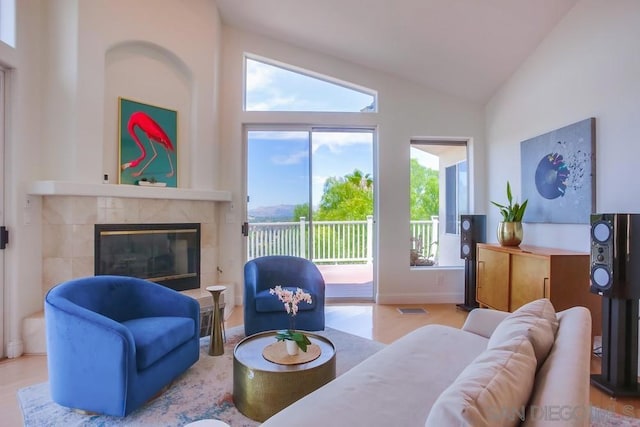 living room featuring a fireplace and high vaulted ceiling