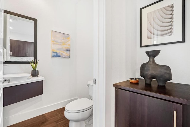 bathroom featuring vanity, wood-type flooring, and toilet