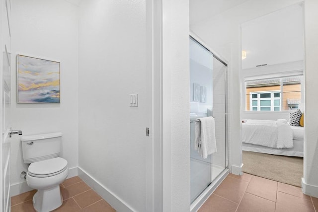 bathroom with an enclosed shower, tile patterned floors, and toilet