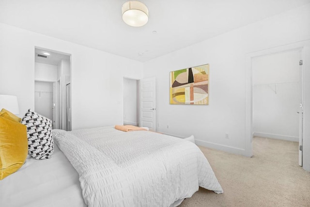 carpeted bedroom featuring a spacious closet and a closet