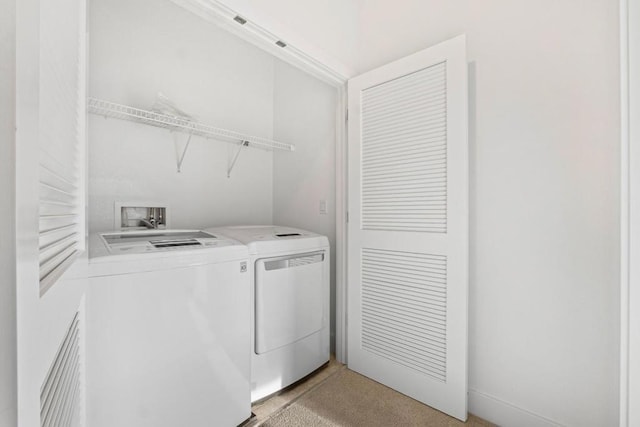 clothes washing area featuring washing machine and dryer and light carpet