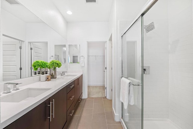 bathroom featuring tile patterned flooring, vanity, and a shower with shower door