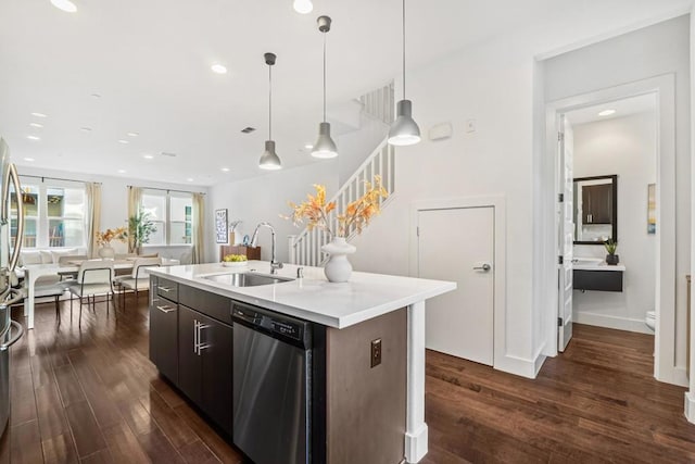 kitchen featuring dishwasher, sink, dark brown cabinetry, dark wood-type flooring, and a center island with sink