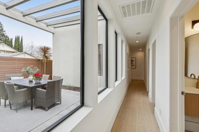 corridor with light hardwood / wood-style flooring