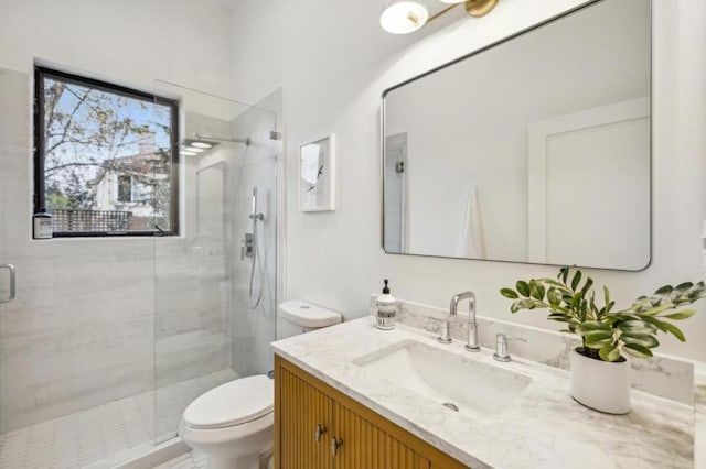 bathroom featuring vanity, an enclosed shower, and toilet