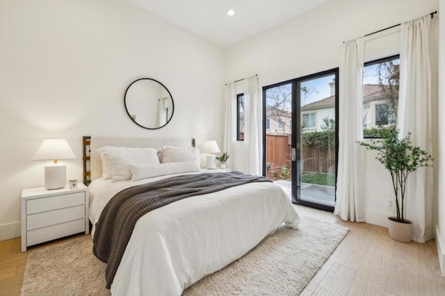 bedroom with access to exterior and light hardwood / wood-style floors